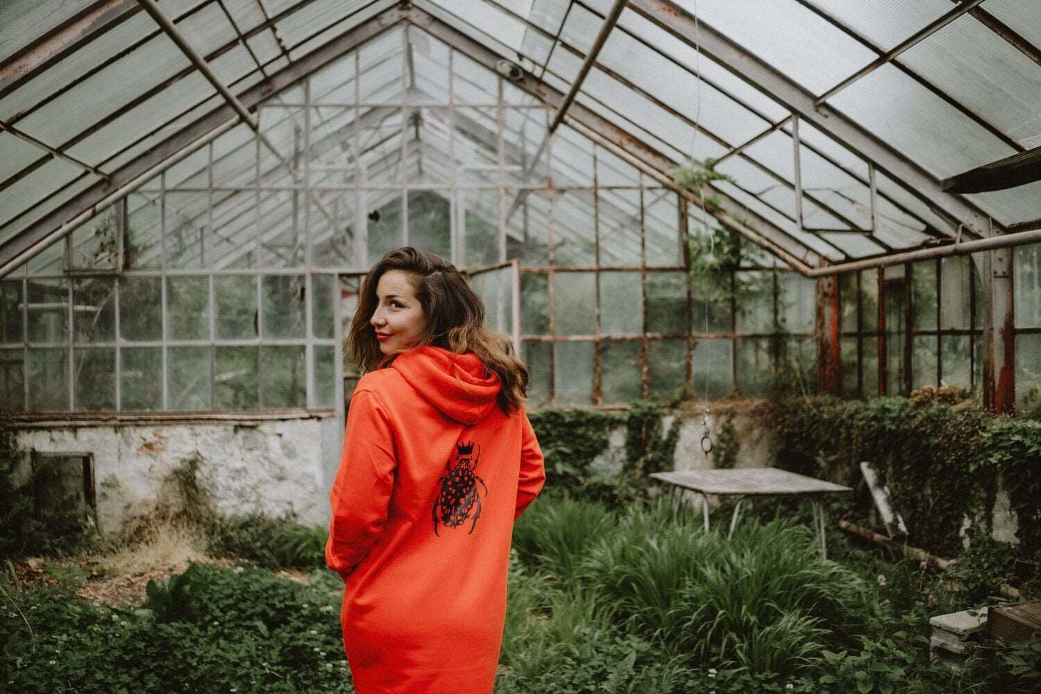 Orangefarbenes Hoodie-Kleid für Damen mit glänzenden schwarzen Käfer auf der Rückseite / Bio-Baumwolle