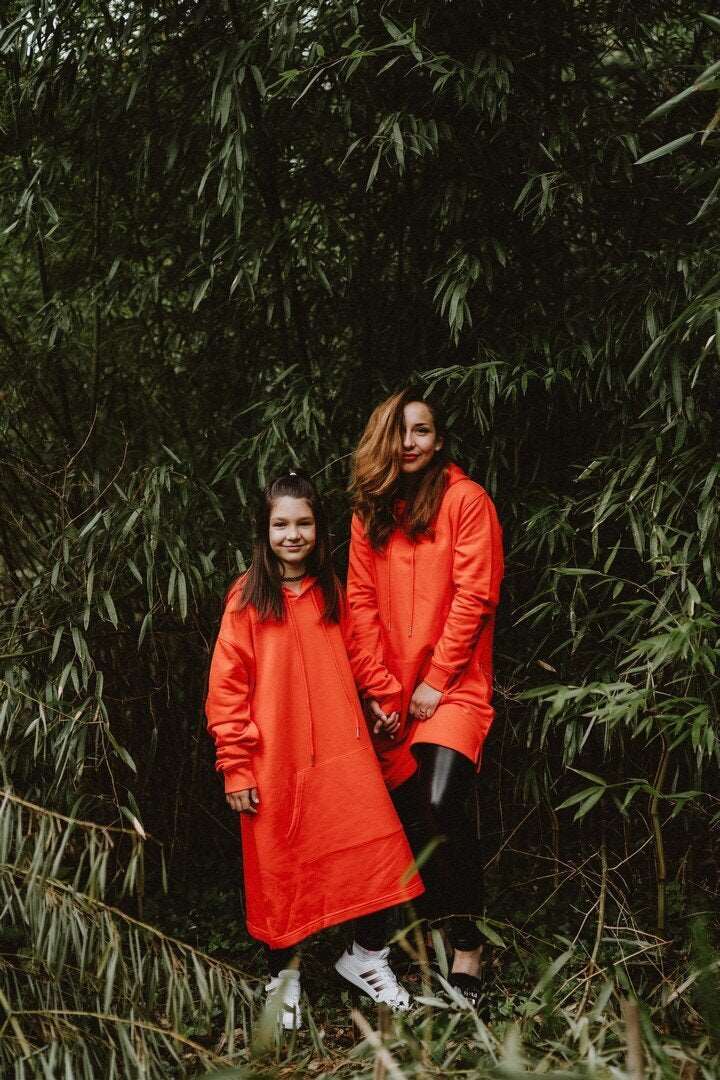 Orangefarbenes Hoodie-Kleid für Damen mit glänzenden schwarzen Käfer auf der Rückseite / Bio-Baumwolle