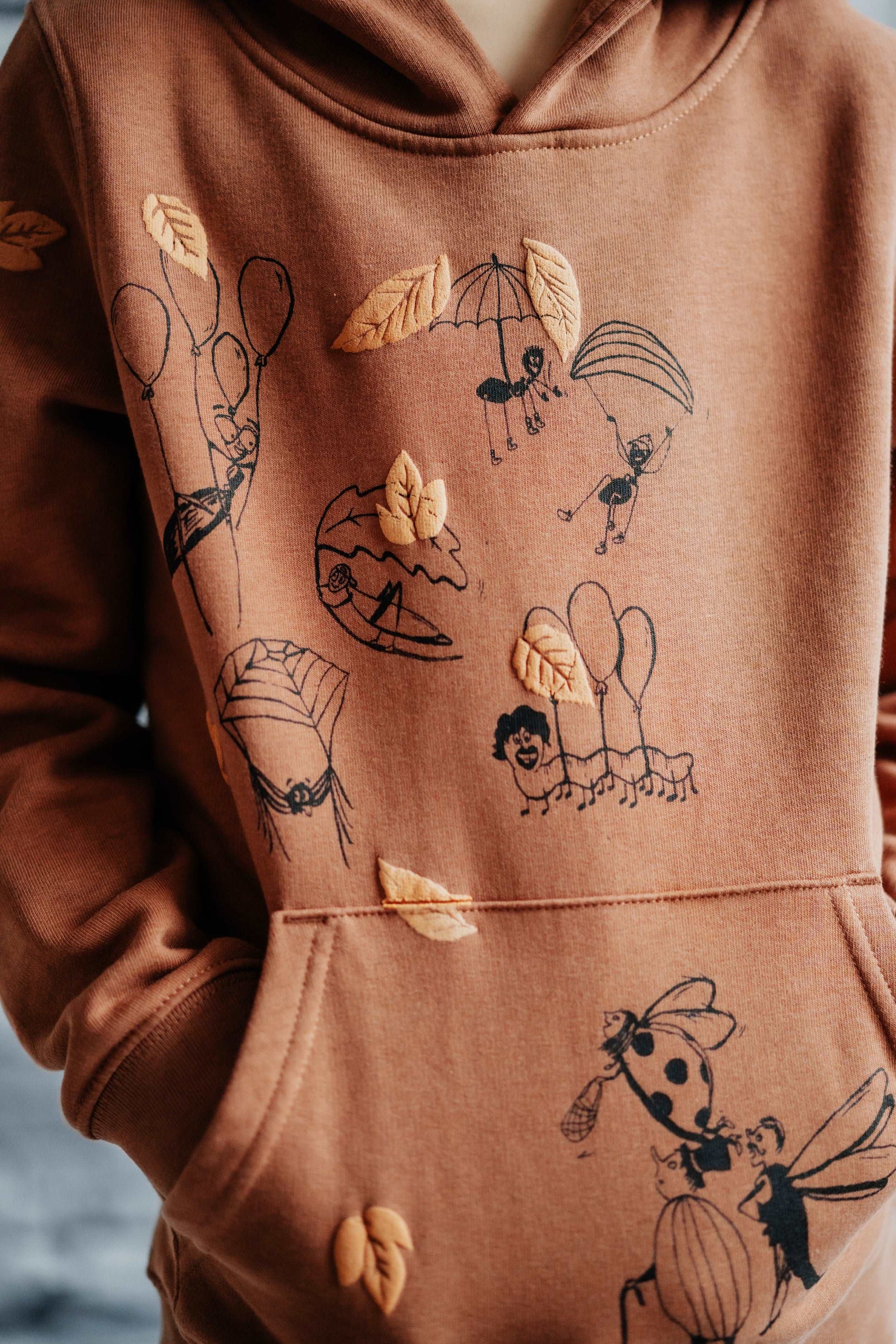 Fallschirmspringer– Zimt-Hoodie mit Frontillustration, Bio-Baumwolle