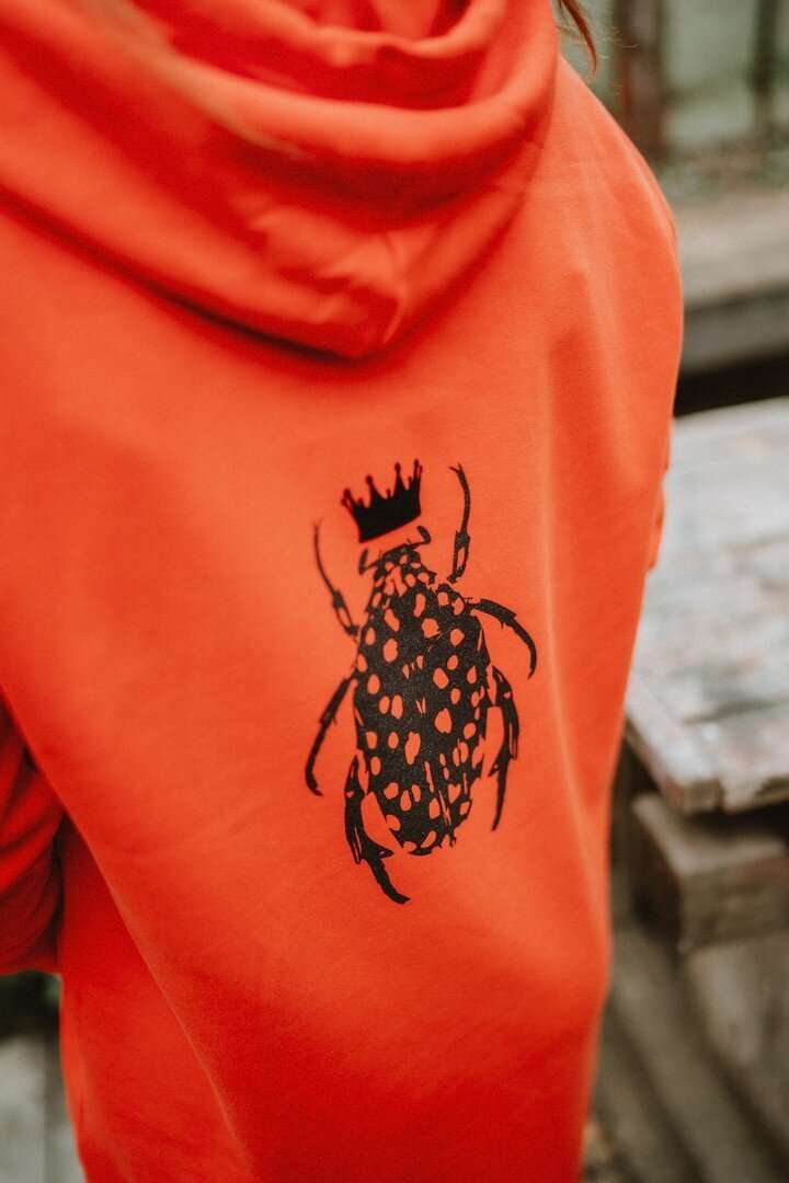 Orangefarbenes Hoodie-Kleid für Damen mit glänzenden schwarzen Käfer auf der Rückseite / Bio-Baumwolle