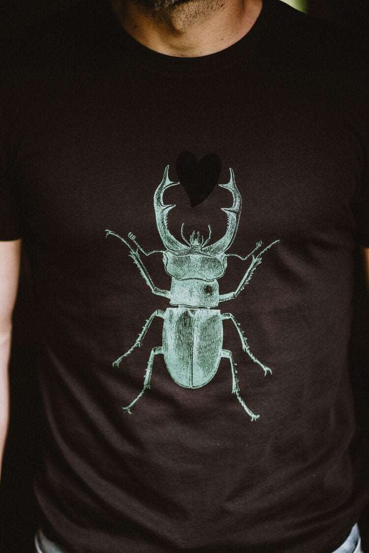 Schwarzes Herren-T-Shirt mit einem grünen Skarabäus, der ein schwarzes Herz hält, 180g Baumwolle
