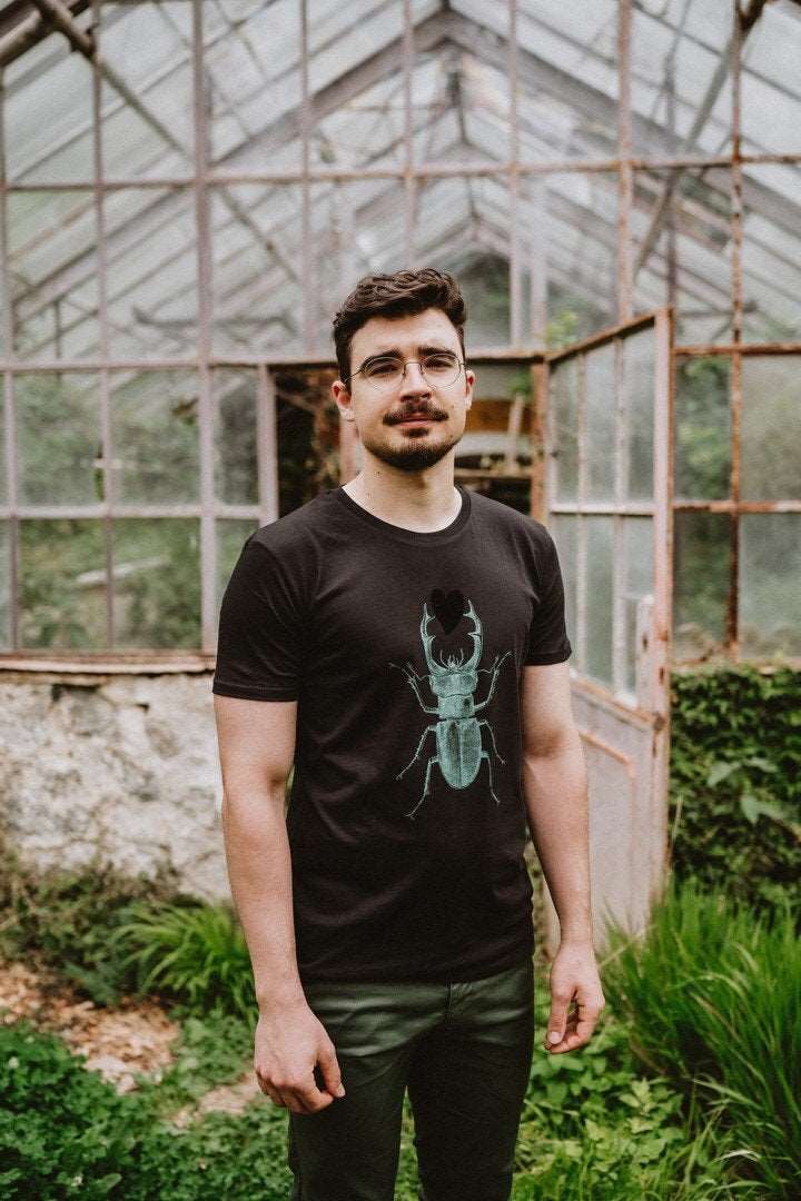 Schwarzes Herren-T-Shirt mit einem grünen Skarabäus, der ein schwarzes Herz hält, 180g Baumwolle