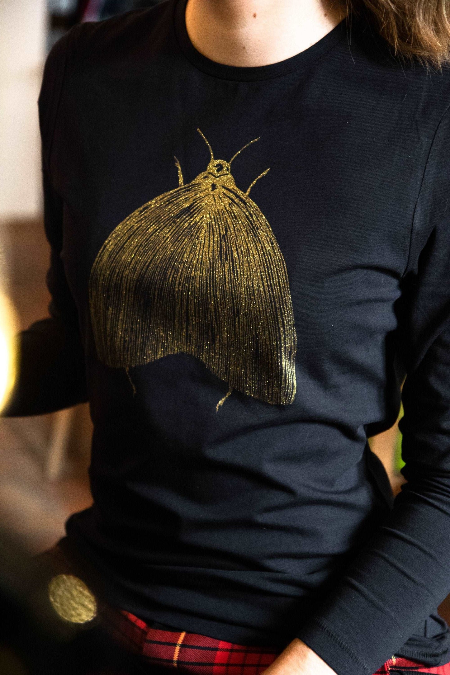 Goldene Motte auf einem schwarzen T-Shirt/  Langarm