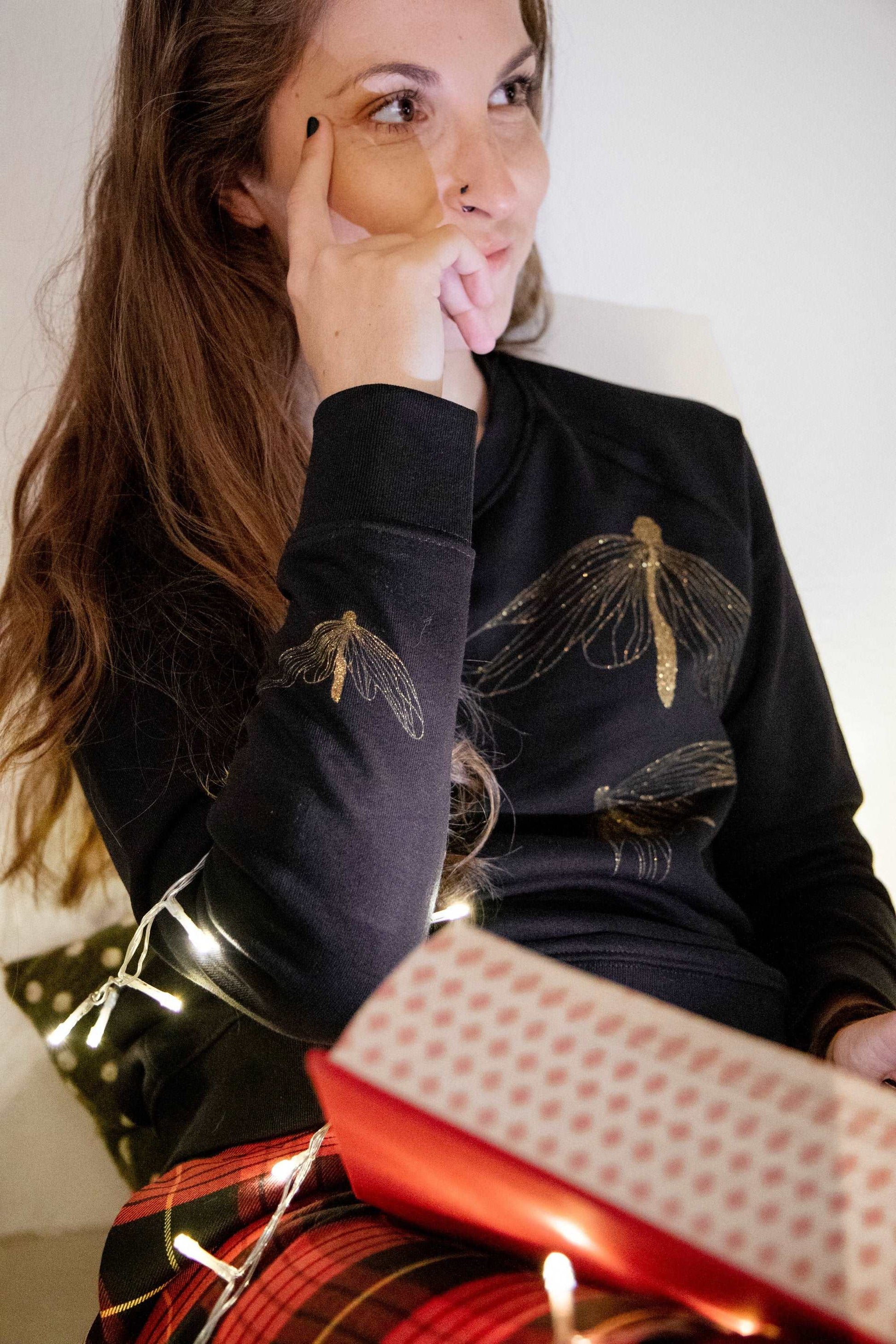Drei goldene Schmetterlinge auf einem schwarzen Pullover (Damen Modell, 300g BioBaumwolle)