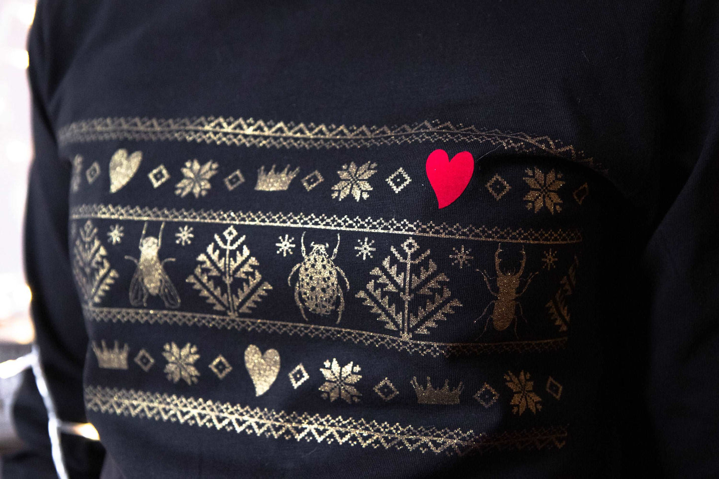 Norwegisches Muster mit Divine Bugs anstelle von Hirsch in Gold auf einem T-Shirt mit Kapuze