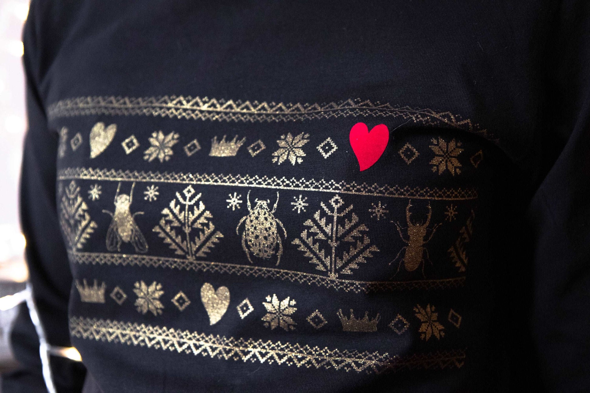 Norwegisches Muster mit Divine Bugs anstelle von Hirsch in Gold auf einem T-Shirt mit Kapuze