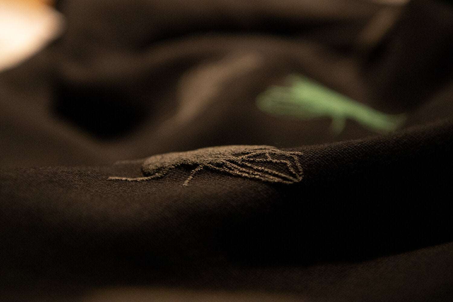 Schwarzer Pullover und 3D-Print einer grauen Fliege, eine grüne ist ebenfalls beteiligt, 350g Bio-Baumwolle
